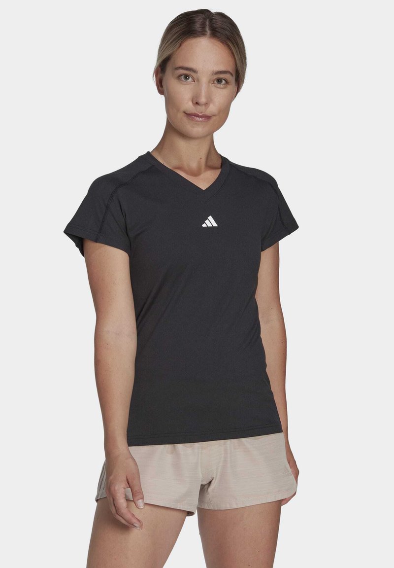 Camiseta deportiva negra con cuello en V y mangas cortas, que presenta un pequeño logotipo blanco en el pecho, fabricada con un material ligero y transpirable.