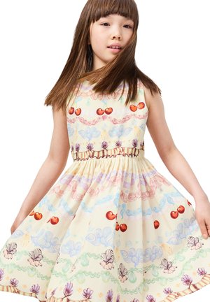 Világos sárga ruha, melynek testhez simuló felső része és bővülő szoknya van. Színes cseresznye, kagyló és hullám minták díszítik különböző pasztell árnyalatokban.