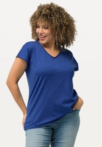 Camiseta azul de cuello en V con mangas cortas, que presenta un acabado texturizado alrededor del escote y las mangas. Con un ajuste suave y relajado.
