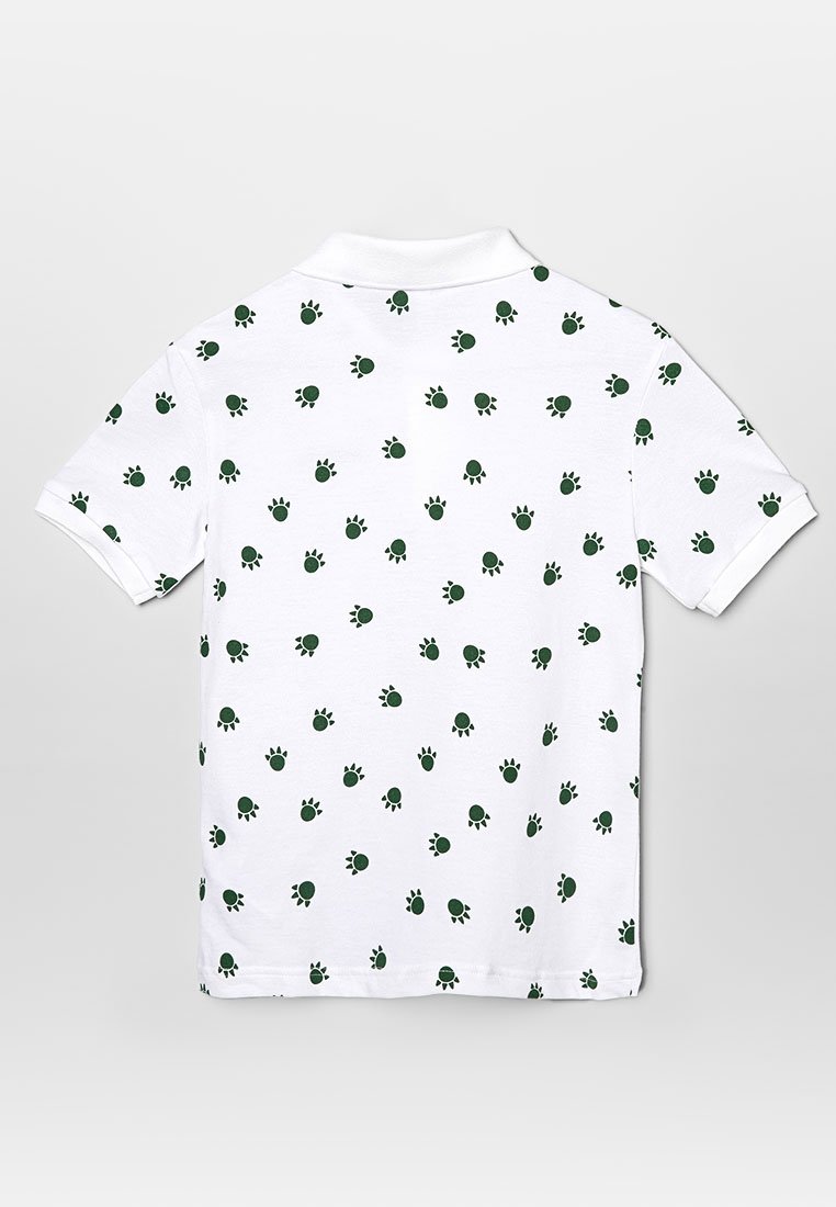 Biała koszulka polo z wzorem małych zielonych żółwi. Posiada klasyczny kołnierzyk i krótkie rękawy, wykonana z bawełnianej tkaniny.