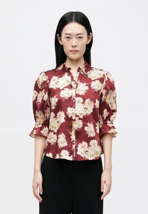 Maroon blouse with floral print, soft satin texture, button front, and gathered puff sleeves. Fitted design with a collar.