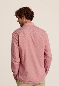 Rood gestreept shirt met een button-down kraag, voorzien van kleine geometrische ontwerpen en een ronde zoom, gemaakt van lichtgewicht stof.