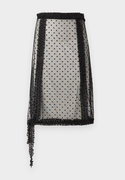 Jupe noire transparente avec motif à pois, bordure à volants et design asymétrique avec un côté plus long, fabriquée en tissu léger.