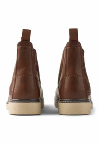 Botas de tobillo de cuero marrón con paneles elásticos en los laterales, tiradores y suelas de color claro. Presentan costuras sutiles y un diseño de punta redondeada.