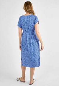 Short-sleeve blue dress with a light floral pattern, cinched waist, and side slits. Made of lightweight fabric, falling below the knee.