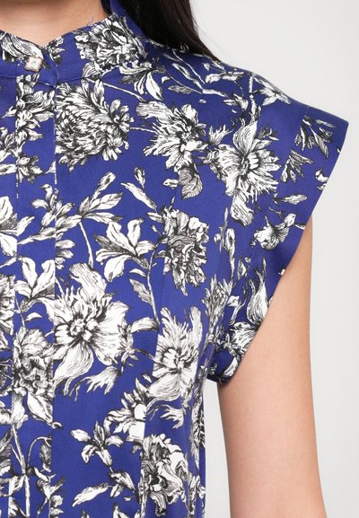 Blue floral shirt featuring black and white botanical prints, short sleeves, button-up collar, and smooth fabric texture.