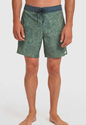 Herren-Badeshorts in Grün mit Blumenmuster, ausgestattet mit einem marineblauen Bund und Schnürung vorne. Leichtes Material und knielanger Schnitt.