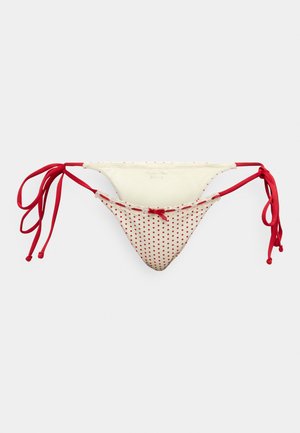 Μαγιό σε κόκκινο και λευκό πουά, με κορδόνια στο πλάι, διαθέτει λεία υφή και καμπυλωτό σχήμα, ιδανικό για μαγιό.