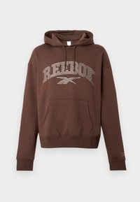 Brūna kapucēta jaka ar lielu pelēku "REEBOK" logotipu, cāļu kabatu, auklu kapuci un ribotu piedurkņu un apakšmalu. Kokvilnas materiāls.
