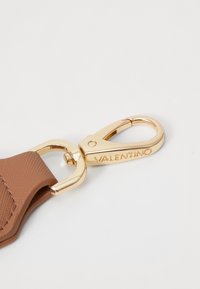 Hnědý texturovaný řemínek se zlatým kovovým zapínáním s vyrytým nápisem "Valentino". Hladký povrch; funkční design; moderní estetika.
