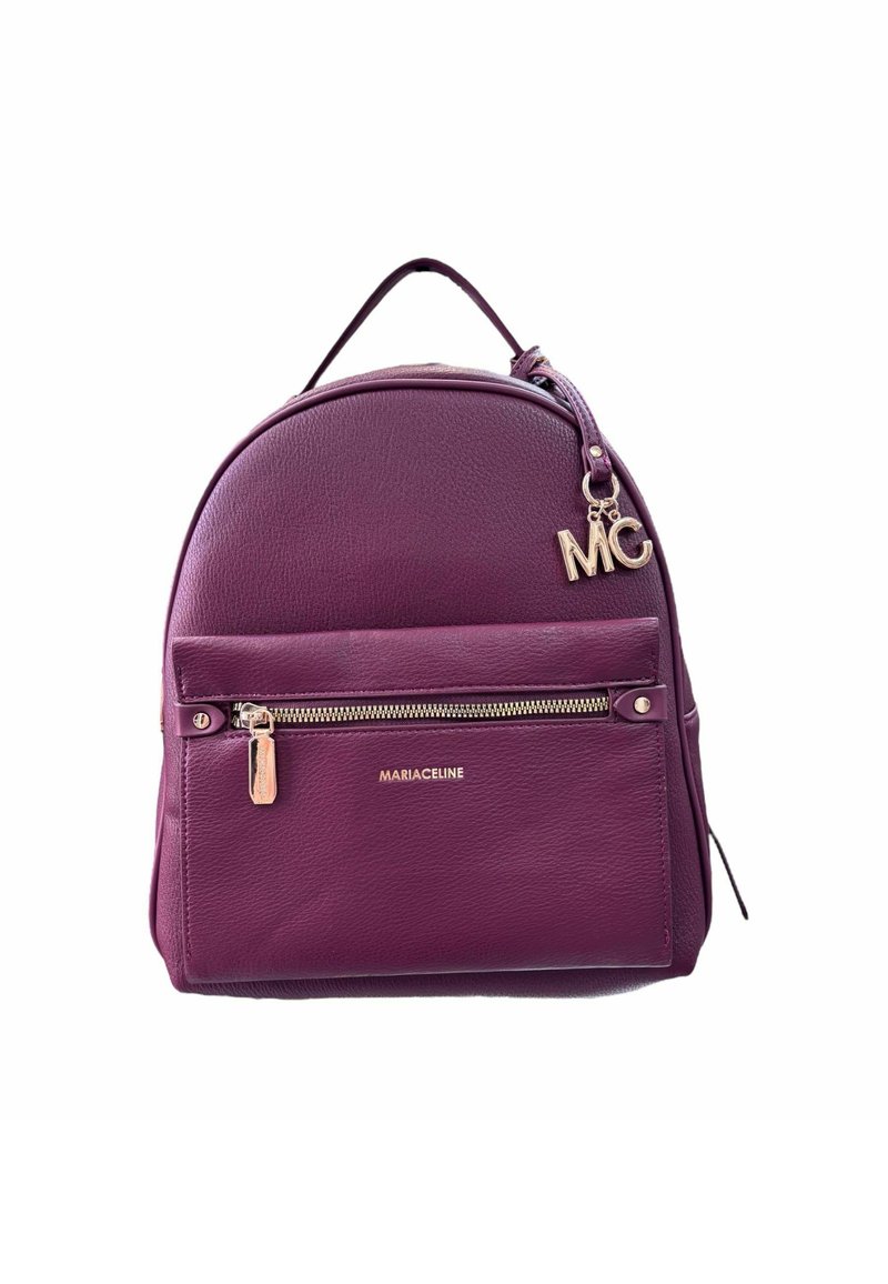 Zaino in pelle viola con forma arrotondata, tasca anteriore con zip, dettagli dorati e un charm removibile con la scritta 'MC'. Nome del brand visibile sulla parte frontale.