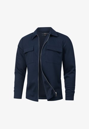 Marineblaue Zip-Jacke mit langen Ärmeln, zwei Brusttaschen und einer glatten Textur. Verfügt über einen Kragen und ein dezentes Vordernahtdetail.