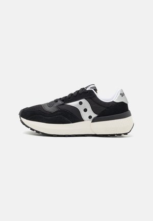 Sneaker sportivo nero realizzato in mesh e suede, con un accento argento, suola bianca e lacci neri, con punta arrotondata e suola spessa.