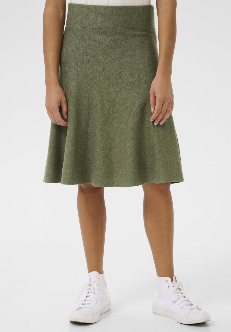 Une jupe verte, à longueur de genoux, évasée, fabriquée en tissu doux avec une texture lisse, dotée d'une large ceinture et sans motifs ni accents visibles.