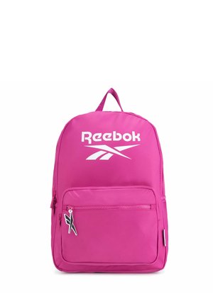 Mochila rosa brillante con un bolsillo frontal con cremallera, logo blanco de Reebok y tirador de cremallera con logo en blanco y negro sobre un fondo blanco.
