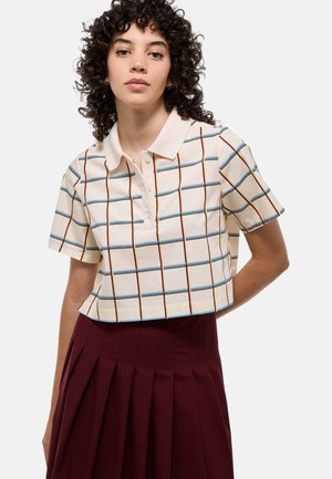 Polo court à col en crème avec un motif quadrillé bleu et rouille. Manches courtes, patte de boutonnage, tissu en coton léger.