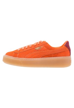 Lavtop orange ruskind sneaker med tyk gummisål, matchende snørebånd, guld Puma-logo og mørkerød hælflap, set fra siden.
