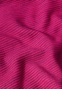 Textil in leuchtendem Fuchsia mit einem gerippten Muster. Das Material wirkt weich und strukturiert mit sichtbaren Strickdetails und Falten.
