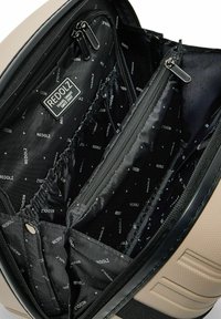 Open zwarte rugzak interieur met meerdere ritscompartimenten en elastische vakken, gevoerd met het merk RedOlz, beige textuur aan de buitenkant.