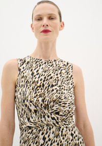 Šaty bez rukávov s bielym základom a čiernobielym leopardím vzorom, s drapériou a detailom s twisted pásom.