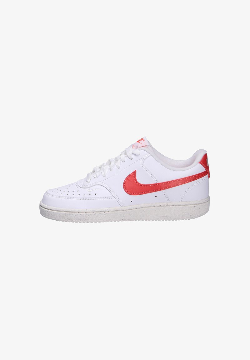 Baskets Nike blanches avec des accents rouges, dotées d'une boîte à orteils perforée, en cuir lisse, avec des lacets plats et une semelle en caoutchouc texturé.