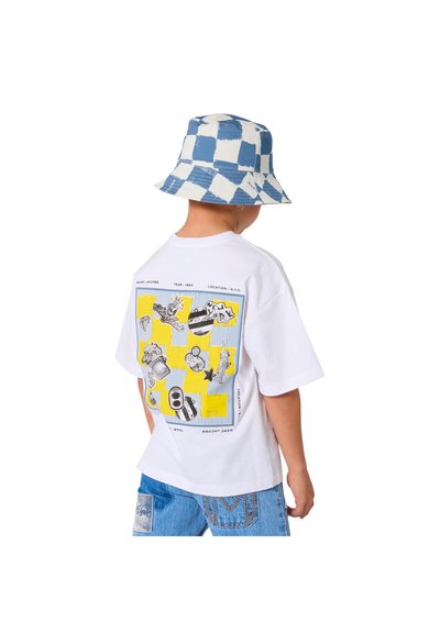 Witte katoenen T-shirt met een kleurrijke grafische print op de achterkant, gecombineerd met een blauw-wit geruit vissershoedje. Casual denim shorts.