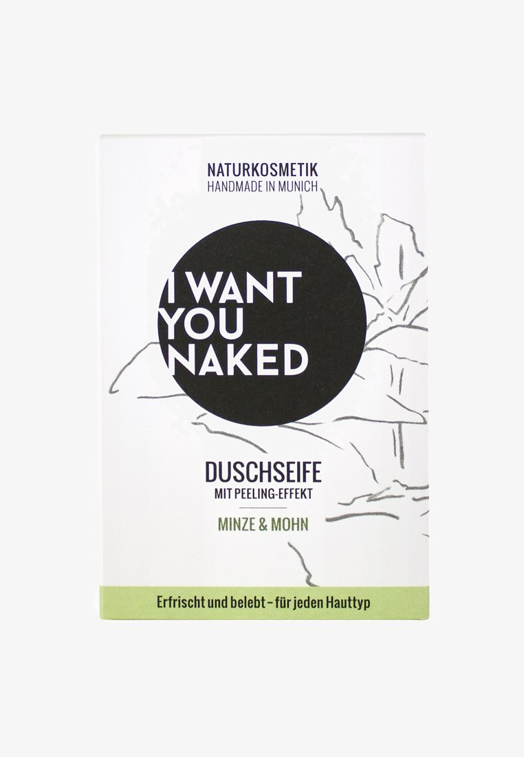 Duschseife bar in white packaging with black and green accents. Features circular label with "I WANT YOU NAKED," botanical line drawings, and text.