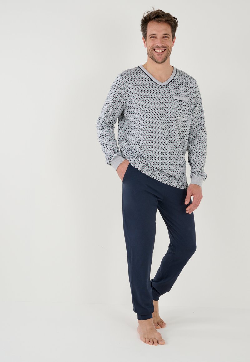 Completo pigiama da uomo con una maglia a maniche lunghe con motivo in azzurro chiaro e dettagli grigi, abbinato a pantaloni blu navy, entrambi realizzati in tessuto morbido.