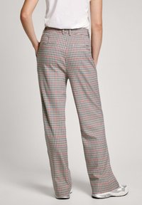 Kalhoty s kostkovaným vzorem v červené, modré a krémové barvě. Široký střih s vysokým pasem a dvěma zadními kapsami. Měkká, texturovaná tkanina.