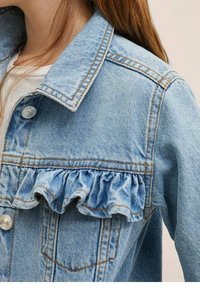 Světlá modrá džínová bunda s řaseným volánem podél předního kapsy, kovovými knoflíky a kontrastním prošíváním.