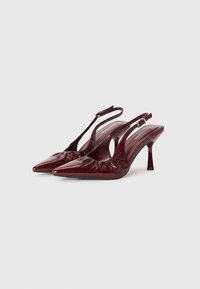 Burgundi odinė slingback bateliai su smailiais pirštais, raukšlėmis, vidutinio aukščio stileto kulnais ir sagtimi reguliavimui.