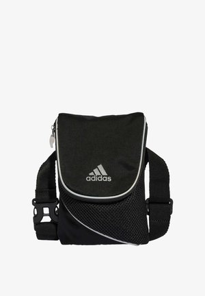 Černá crossbody taška Adidas se zipovým uzávěrem, síťovanými panely, nastavitelným popruhem a stříbrným logem na přední straně. Kompaktní design.