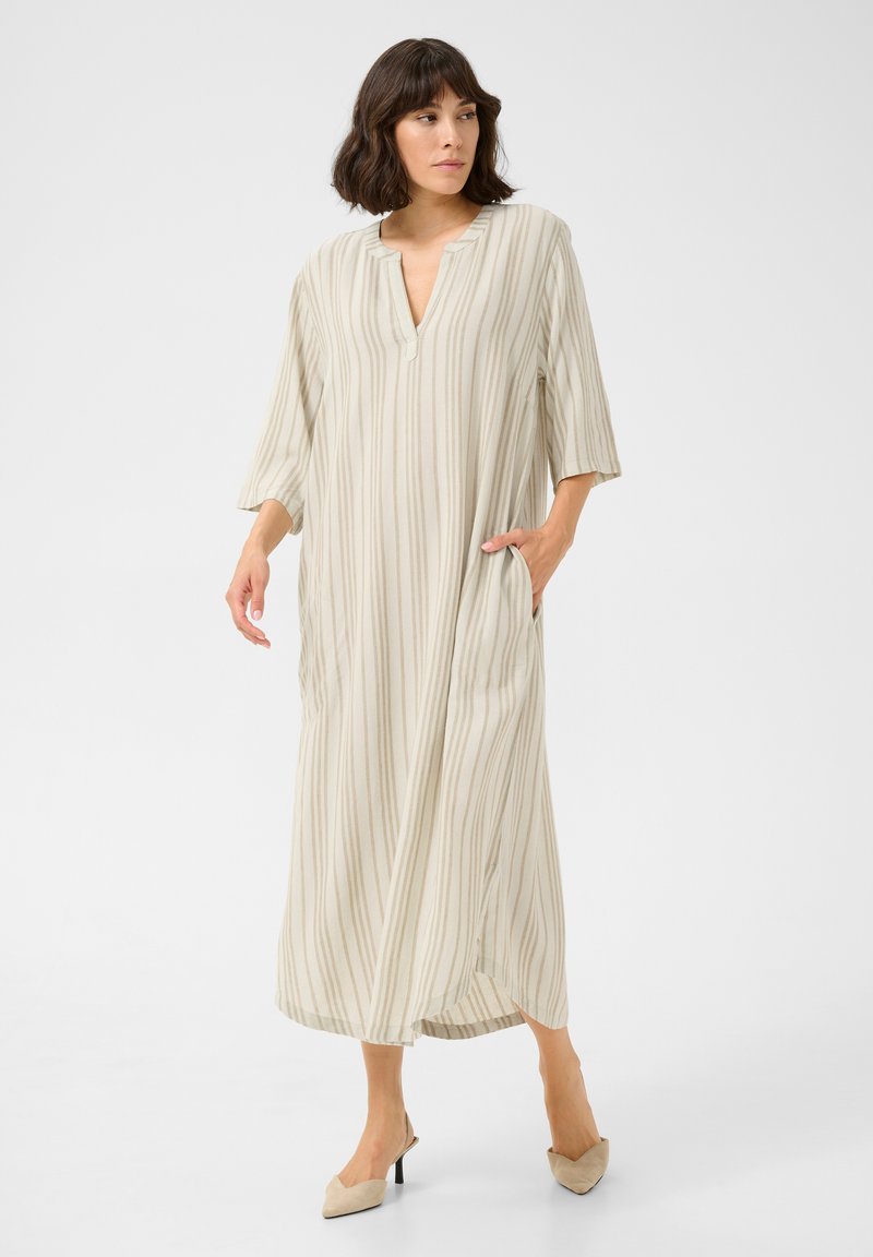 Robe maxi rayée beige avec un décolleté en V, des manches trois-quarts et des poches latérales ; confectionnée en tissu léger avec une texture lisse.