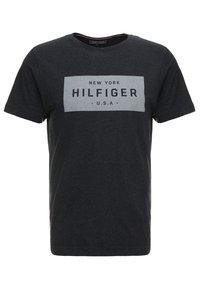 Černé bavlněné tričko s kulatým výstřihem. Obsahuje šedou obdélníkovou grafiku s nápisem "NEW YORK HILFIGER U.S.A." vytištěným tučným písmem.