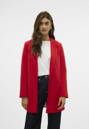 Red blazer with a tailored fit, open front, and long sleeves. Worn over a white top and paired with dark blue jeans. Smooth texture.