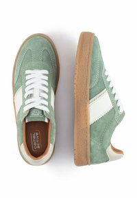 Grüne Wildledersneaker mit weißen Lederakzenten, ausgestattet mit einer Schnürung und strukturierten Gummi-Sohlen.
