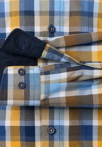 Karierte Hemd mit blauen, gelben, weißen und braunen Quadraten, ausgestattet mit dunkelblauen Knöpfen und einem umgeschlagenen Ärmel Detail.