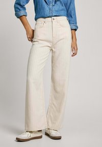 Jeans de pierna ancha y cintura alta en color crema claro con rayas verticales rosas. Hechos de denim, cuentan con un cierre de botón y un diseño de cinco bolsillos.