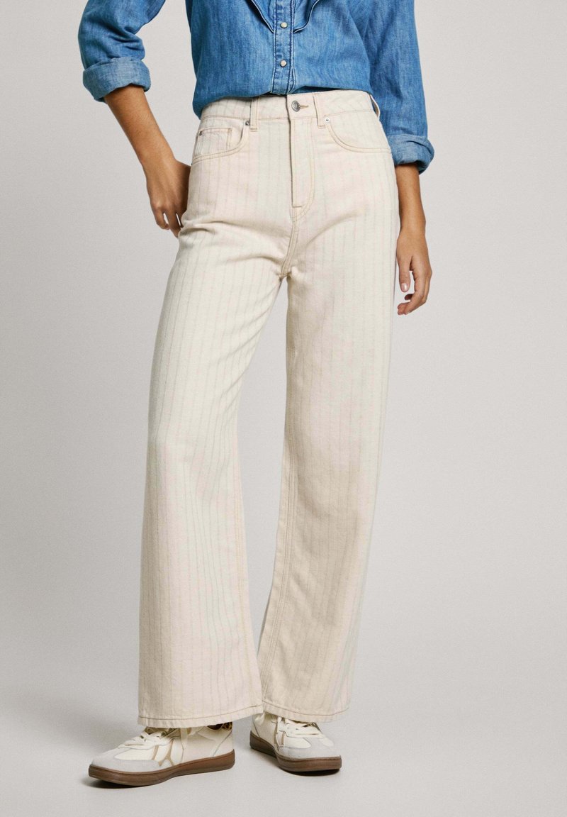 Jeans de pierna ancha y cintura alta en color crema claro con rayas verticales rosas. Hechos de denim, cuentan con un cierre de botón y un diseño de cinco bolsillos.
