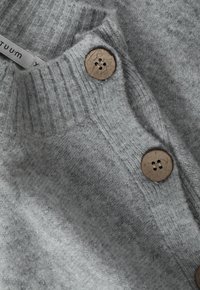 Pull en tricot gris texturé avec un col côtelé, doté de deux grands boutons ronds marron à l'avant pour la fermeture.