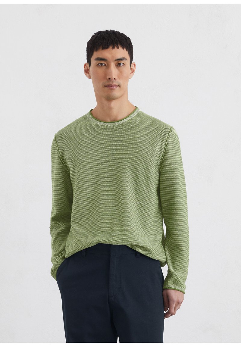 Pull à col rond à manches longues rayé vert en tissu texturé. Assorti à un pantalon sombre, offrant une coupe décontractée et un design simple.