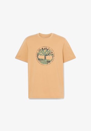 Beige T-Shirt mit kurzen Ärmeln, bedruckt mit einem grünen Baum in einem Kreis und dem Text "Timberland" sowie "Seit Neunzehnhundertdreiundsiebzig."