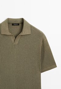 Polo shirt lavorato a maglia verde oliva con maniche corte, caratterizzato da un motivo testurizzato e colletto a V. Etichetta con la scritta "Massimo Dutti."