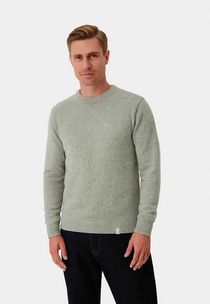 Pull léger vert en maille texturée. Doté d'un col rond, de poignets et d'un ourlet côtelés, avec une petite étiquette sur le bas.