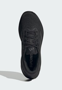 Scarpa sportiva nera con tomaia in mesh tessurizzato, lacci piatti e punta rinforzata. Presenta il marchio sulla linguetta e una soletta imbottita.