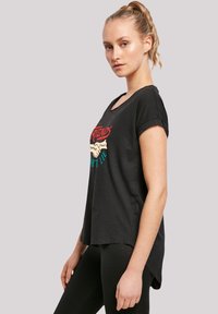 Schwarzes Baumwoll-T-Shirt mit kurzen, gerollten Ärmeln, das ein farbenfrohes "Stranger Things"-Grafikdesign zeigt und einen lässigen Schnitt hat.