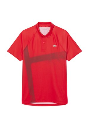 Polo shirt rouge avec un col, des manches courtes et un motif abstrait noir sur le devant. Présente un logo vert sur la poitrine.