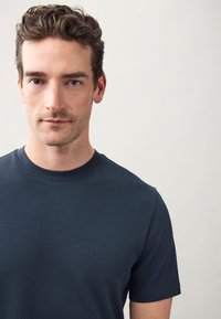 Navy blue cotton t-shirt with a crew neckline, short sleeves, smooth texture, and no visible patterns or accents.