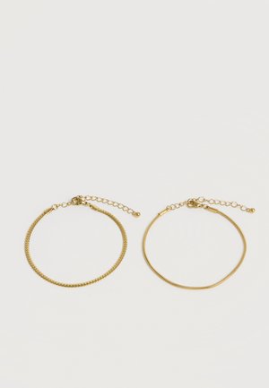 Twee verstelbare kettingarmbanden in goudkleur, één met een plat schakelontwerp en één met een gladde slangketting, naast elkaar weergegeven.