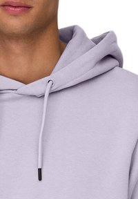 Licht lavendelkleurige hoodie met een trekkoordsluiting, zachte textuur en een ontwerp met een voorzak. Geschikt voor casual draag.